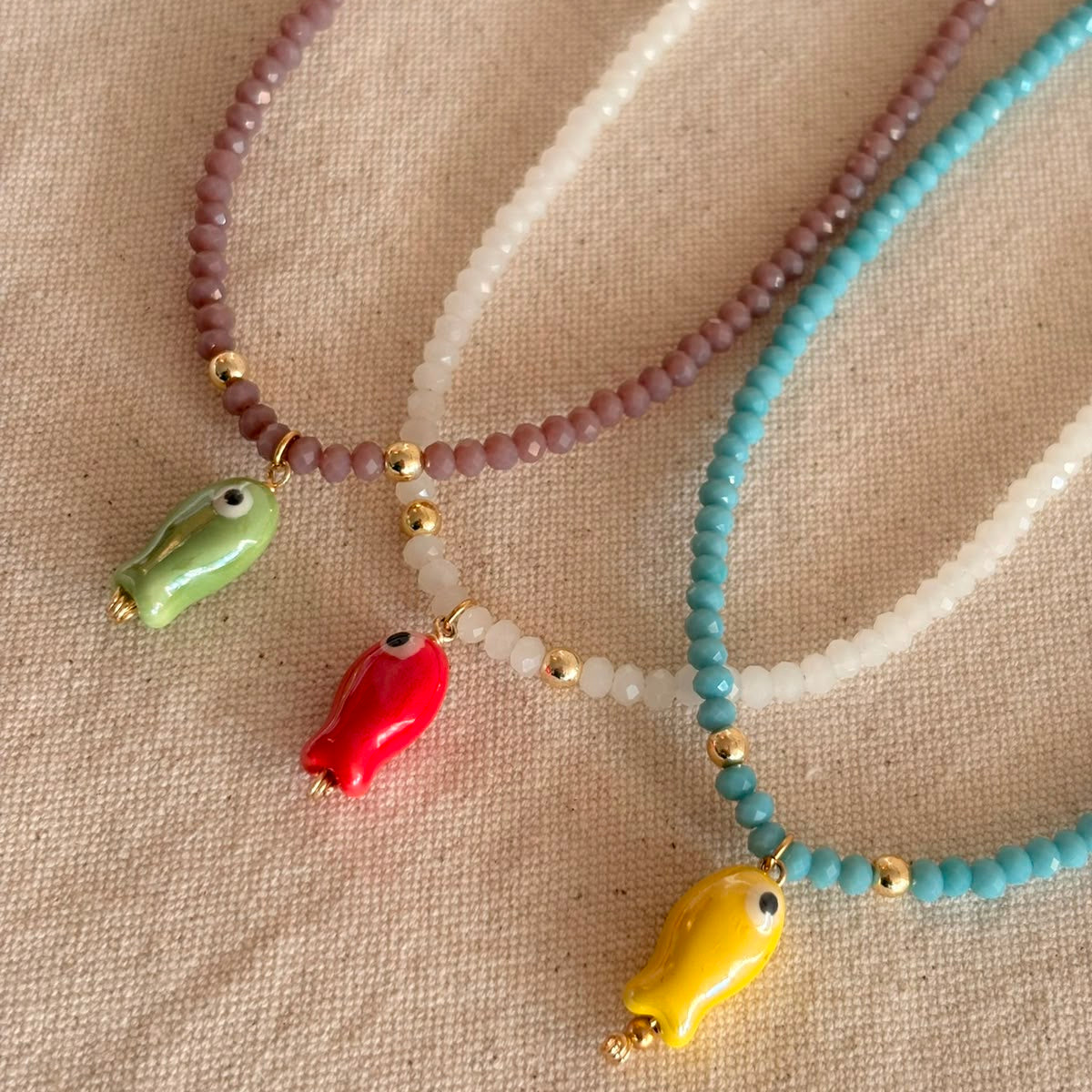 Collar de cristales, con aplicacion de dije de pez, hecho a mano en Chile.